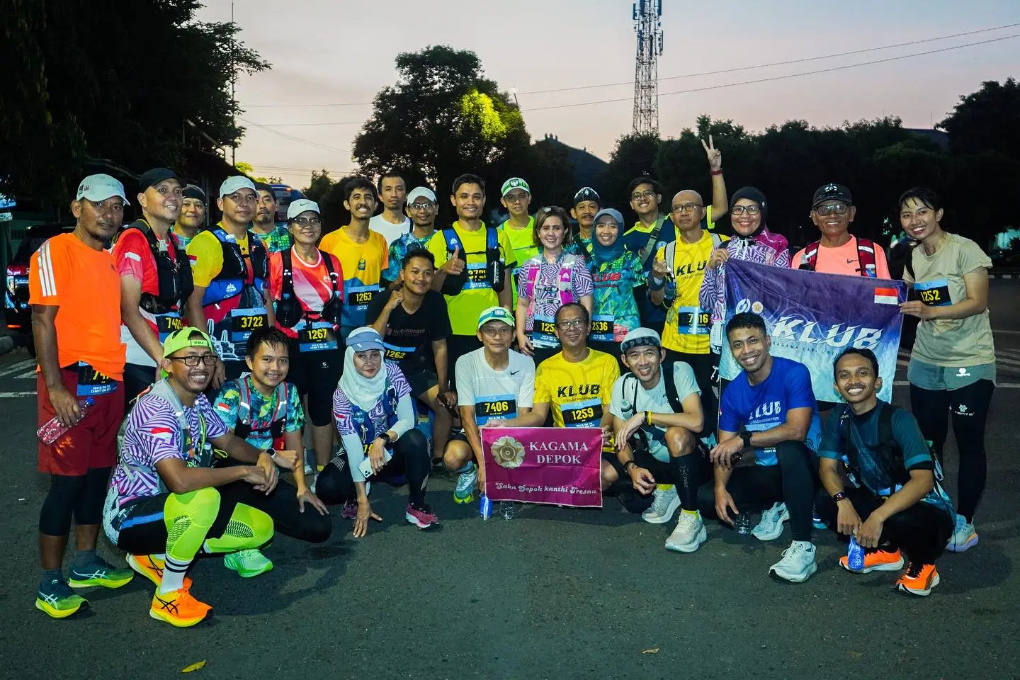 Para pelari berfoto bersama saat fajar dengan spanduk KLUB